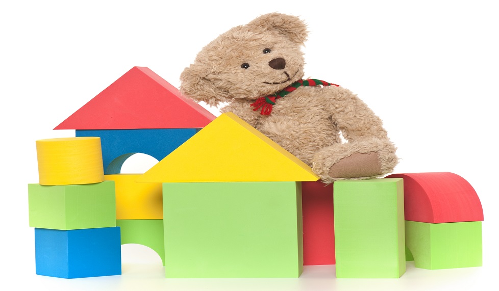 Colorful foam children's building blocks isolated on white background with teddy bear.